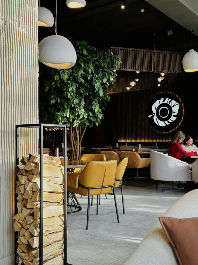 A modern cafe interior featuring cozy seating, warm lighting, and wood accents for a relaxing ambiance.