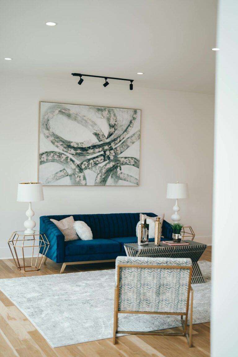 Stylish living room interior featuring a blue sofa, abstract artwork, and decorative lamps.